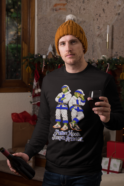 Man in a beanie by a Christmas tree wearing the Leeds white Santa chimps sweatshirt