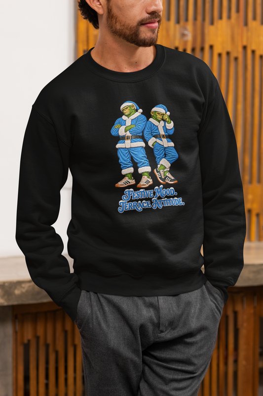 Man in grey trousers wearing the black sky blue Santa chimps Christmas jumper