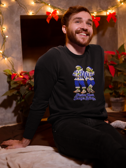 Smiling man by Christmas lights wearing the blue and white striped Northern Monkeys jumper