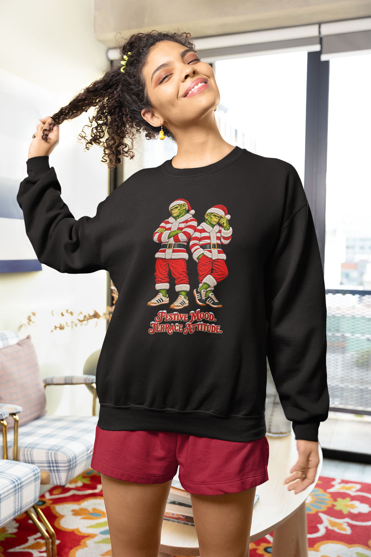 Woman in red shorts wearing the black red and white hooped Santa chimps sweatshirt