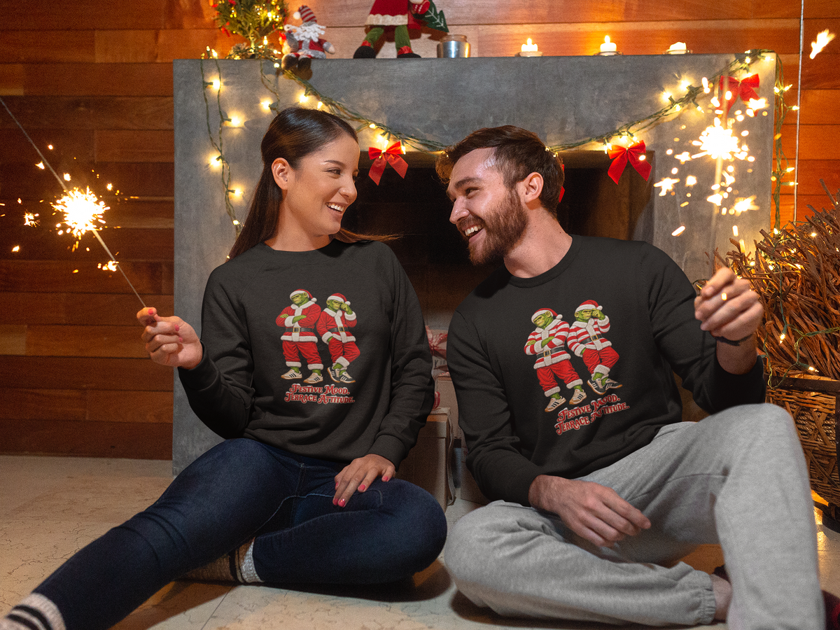 Couple by Christmas lights both wearing the red and white hoops Northern Monkeys Christmas jumper