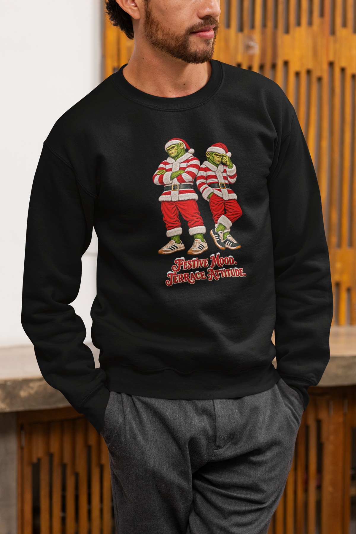 Man in grey trousers wearing the black red and white hooped Santa chimps Christmas jumper