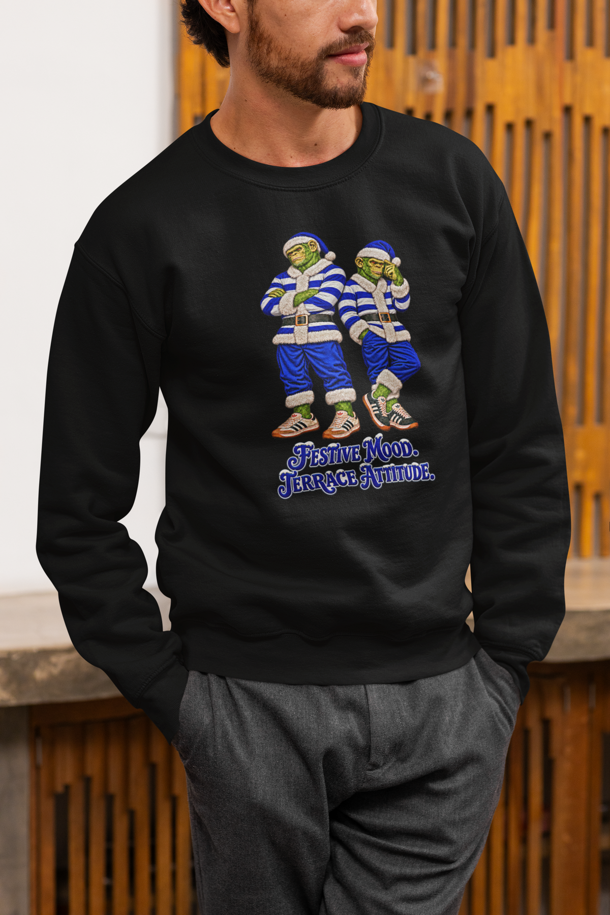 Man in grey trousers wearing the black blue and white hoops Santa chimps sweatshirt