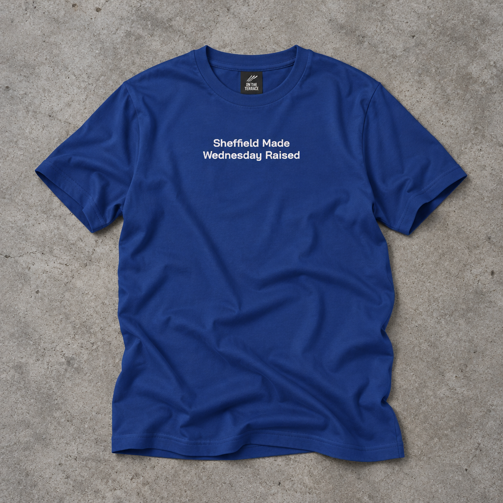 Royal blue embroidered Sheffield Made Wednesday Raised tee laid flat on concrete