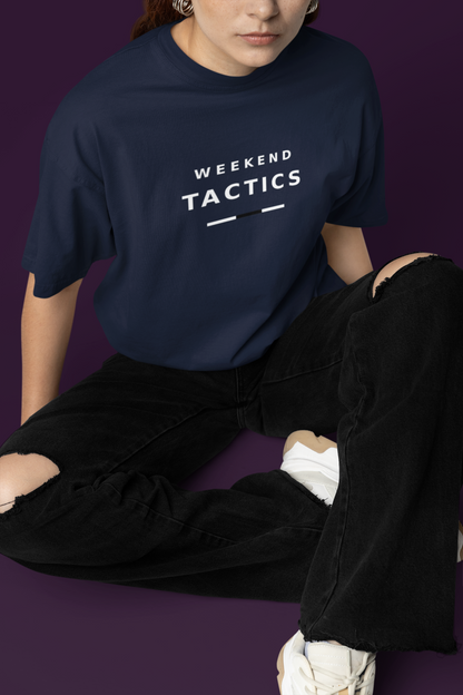 Woman sitting on the floor in the navy Weekend Tactics T-shirt and black trousers