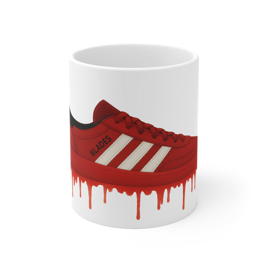 White mug with illustration of a red sneaker labeled Blades above red paint drips