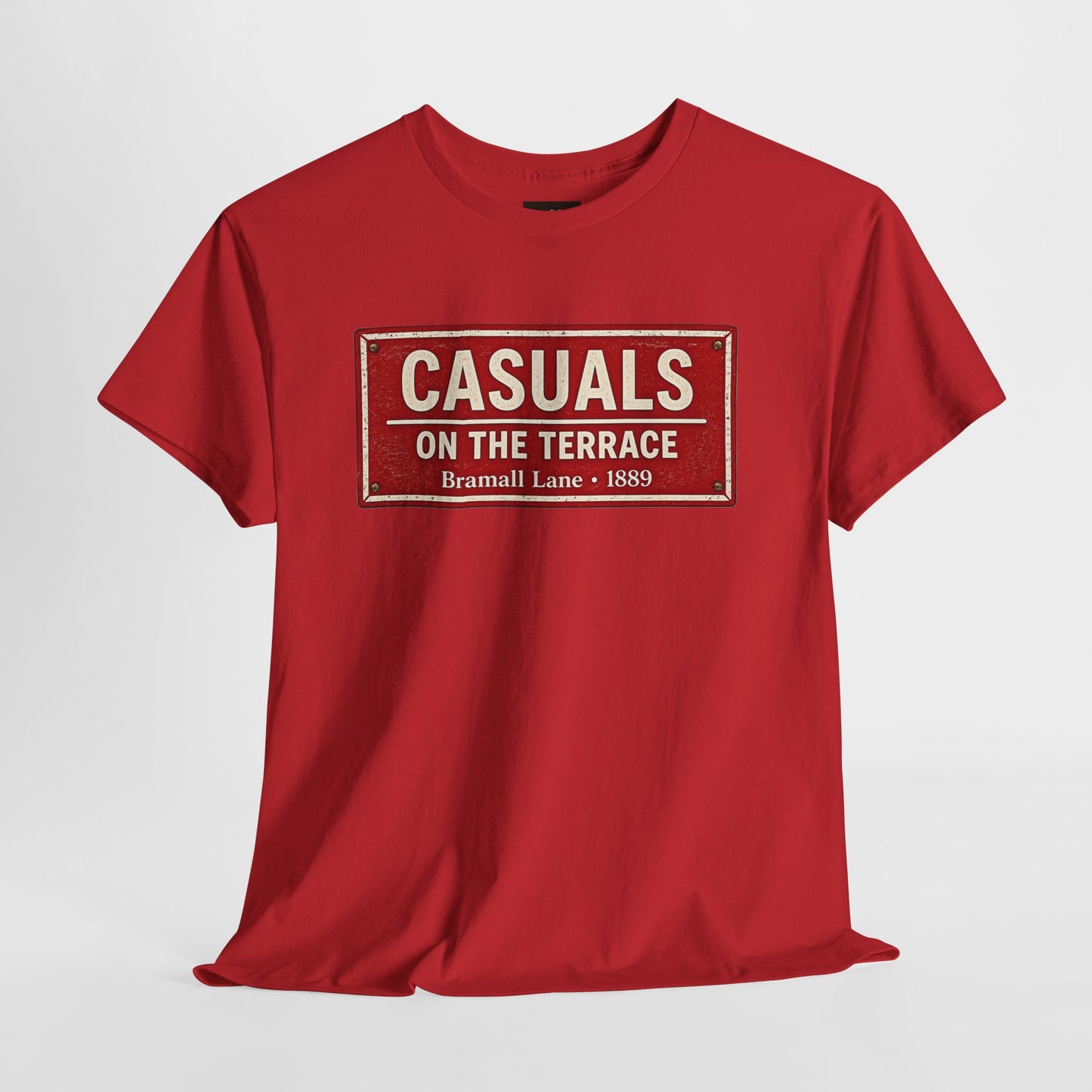 A red SUFC t-shirt flat lay featuring a central vintage red and white street sign graphic reading "CASUALS ON THE TERRACE" with "Bramall Lane • 1889" printed below, and an inner neck label for On The Terrace.on a white background