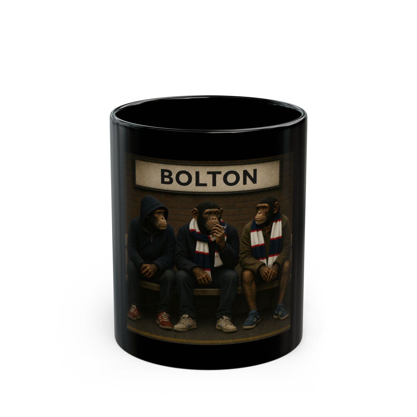 A high-gloss black ceramic mug features a rectangular graphic of three chimpanzees dressed as 1980s football casuals sitting on a railway platform bench. Above them hangs a vintage cream station sign with the word "BOLTON" in black capital letters. The monkeys wear casual coats, hoodies, retro low-profile trainers, and navy, white, and red striped bar scarves against a brick wall background.