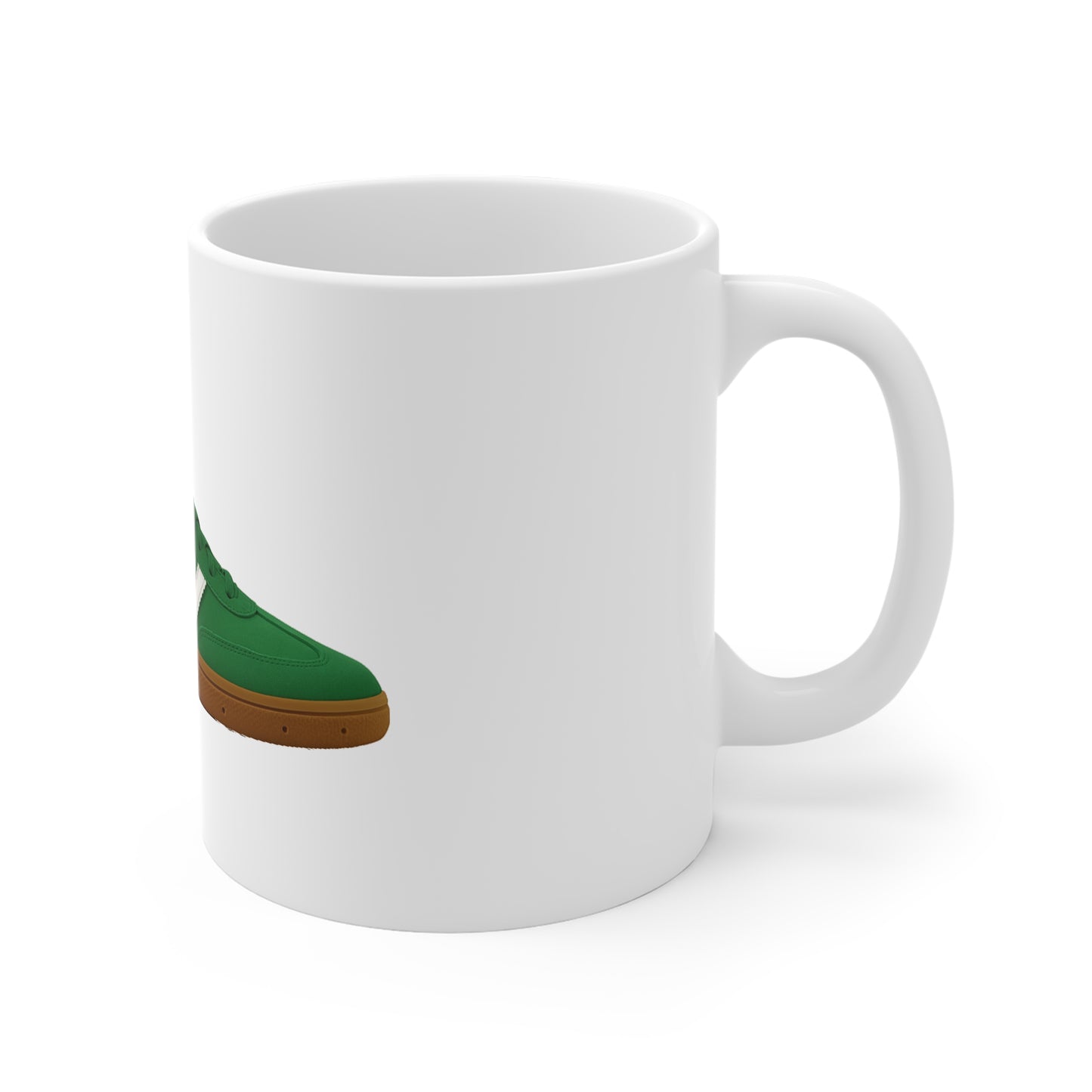 White ceramic mug featuring a green sneaker with brown sole design, side view on white background