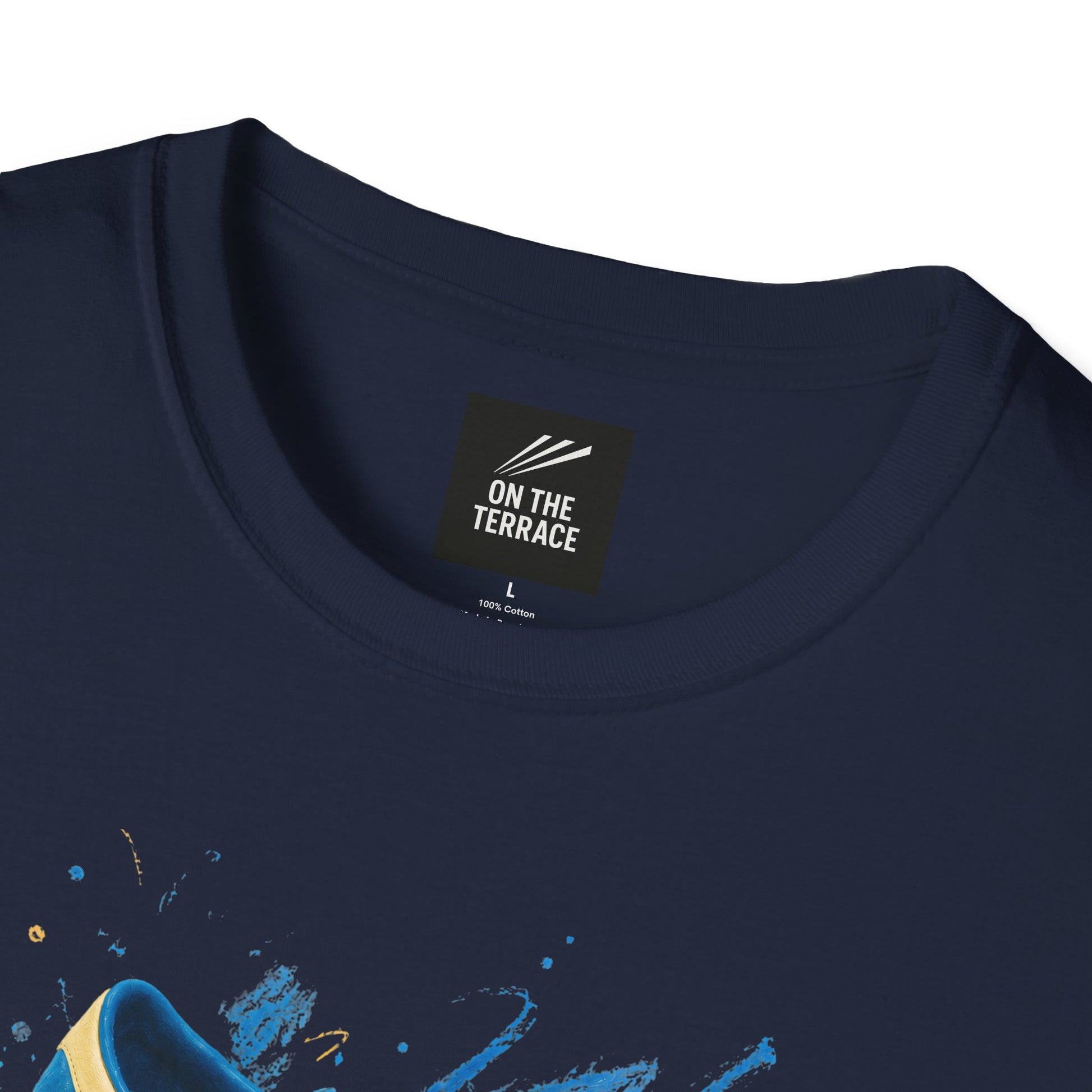Navy blue t-shirt with a printed graphic of a blue suede trainer featuring cream stripes and a gum sole, surrounded by a blue and gold paint splatter design, with an "On The Terrace" logo on the neck label.