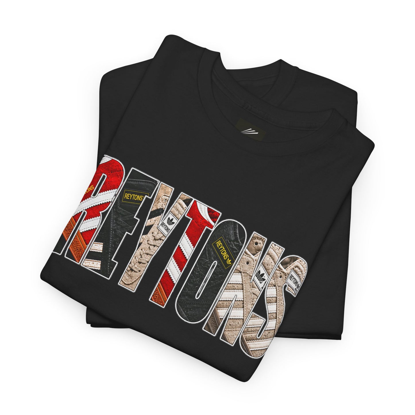 A folded black Reytons t-shirt with a large graphic print reading 'Reytons' in a distressed, multi-patterned font featuring red, white, black, and beige designs, on a plain white background.