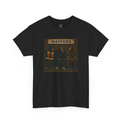 A black short-sleeve Watford t-shirt featuring a rectangular graphic print on the chest. The graphic shows three hooded figures sitting on a bench under a sign that reads 'WATFORD' in beige letters, with a dark background.