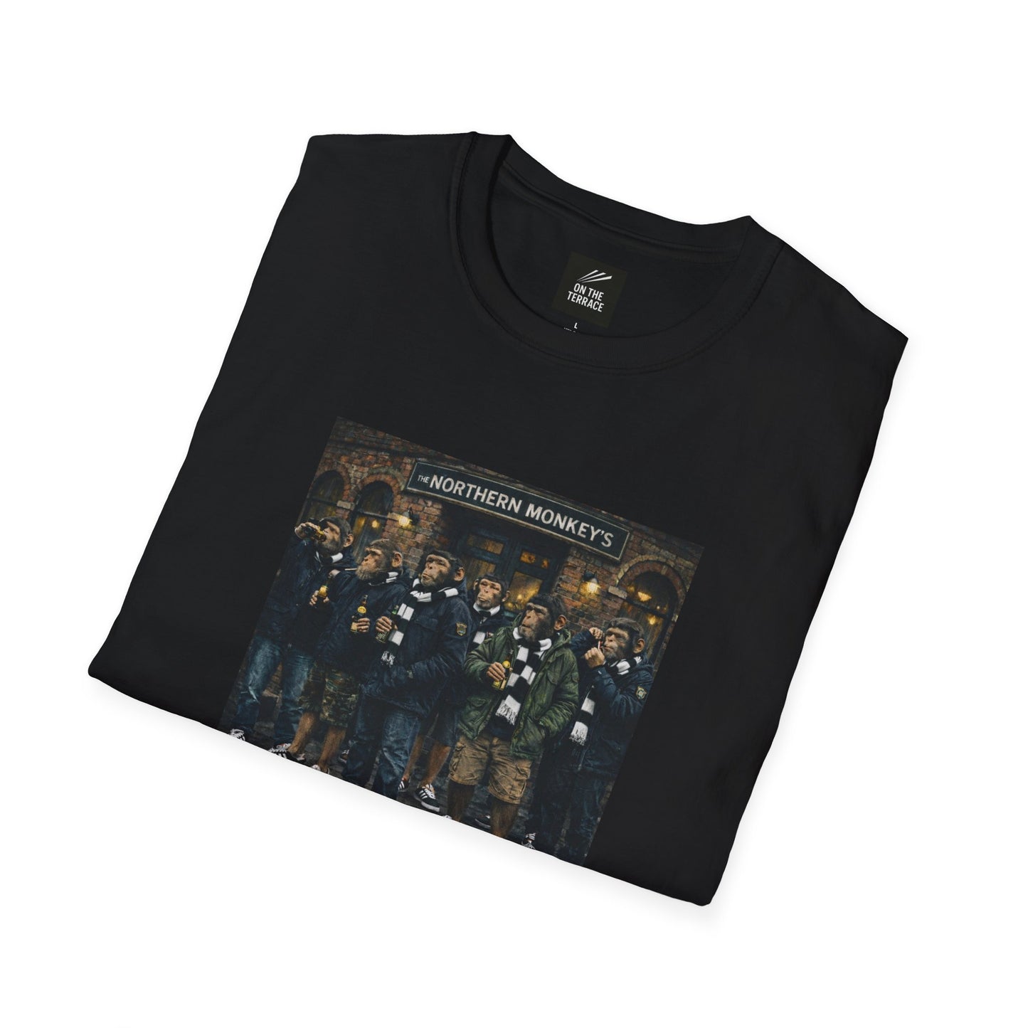 A front-facing view of a black crewneck t-shirt featuring a central graphic illustration. The artwork depicts seven chimpanzees dressed in British "terrace culture" fashion—wearing olive and navy parkas, puffer jackets, black-and-white striped scarves, and black trainers. They are gathered in front of a traditional brick pub with a sign that reads "THE NORTHERN MONKEY'S."