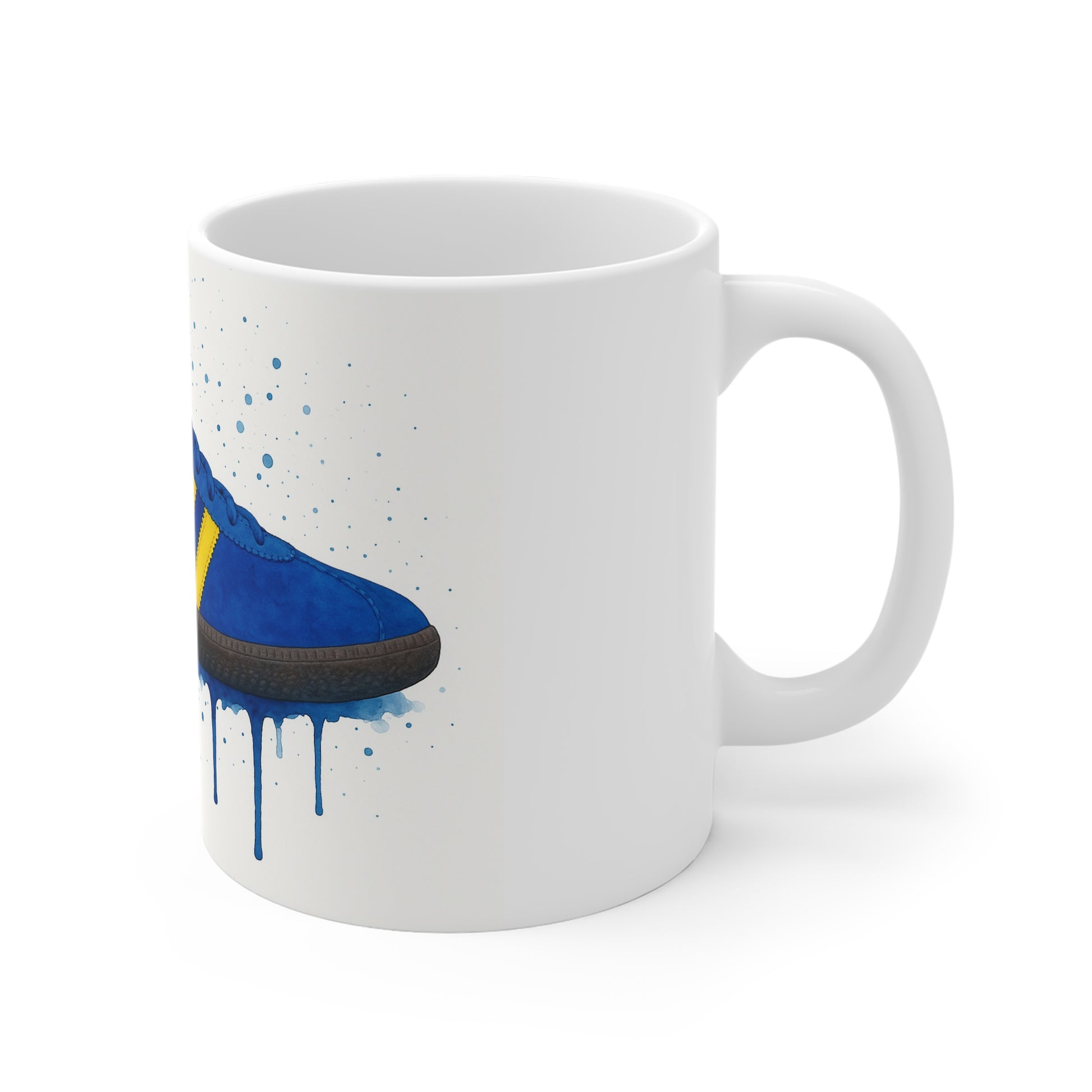 White ceramic mug with blue and yellow sneaker watercolor design and paint splatter