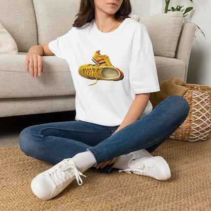 Person wearing a white t-shirt with hand-illustrated yellow, navy and red retro terrace trainer sneaker graphic print, On The Terrace casual clothing brand
