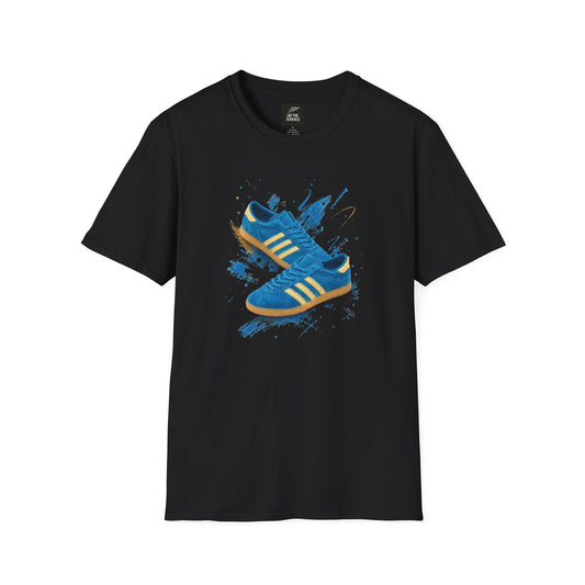 A black short-sleeve crewneck t-shirt featuring a graphic print of two blue Adidas sneakers with yellow stripes on a blue paint splatter background.