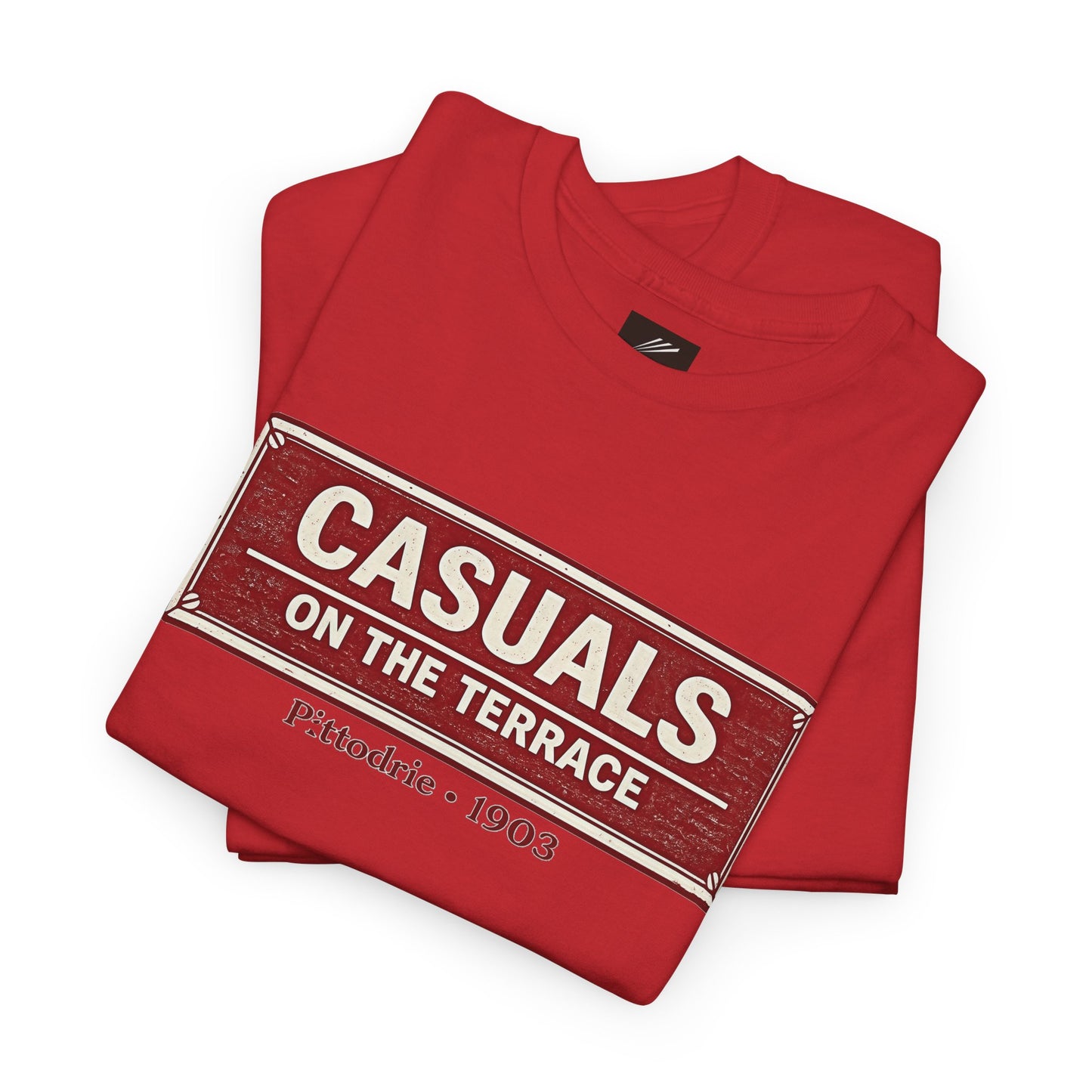 A folded red heavy cotton Aberdeen t-shirt flat lay featuring a central vintage red and white street sign graphic reading "CASUALS ON THE TERRACE" with "Pittodrie • 1903" printed below, and an inner neck label for On The Terrace. on a white background.