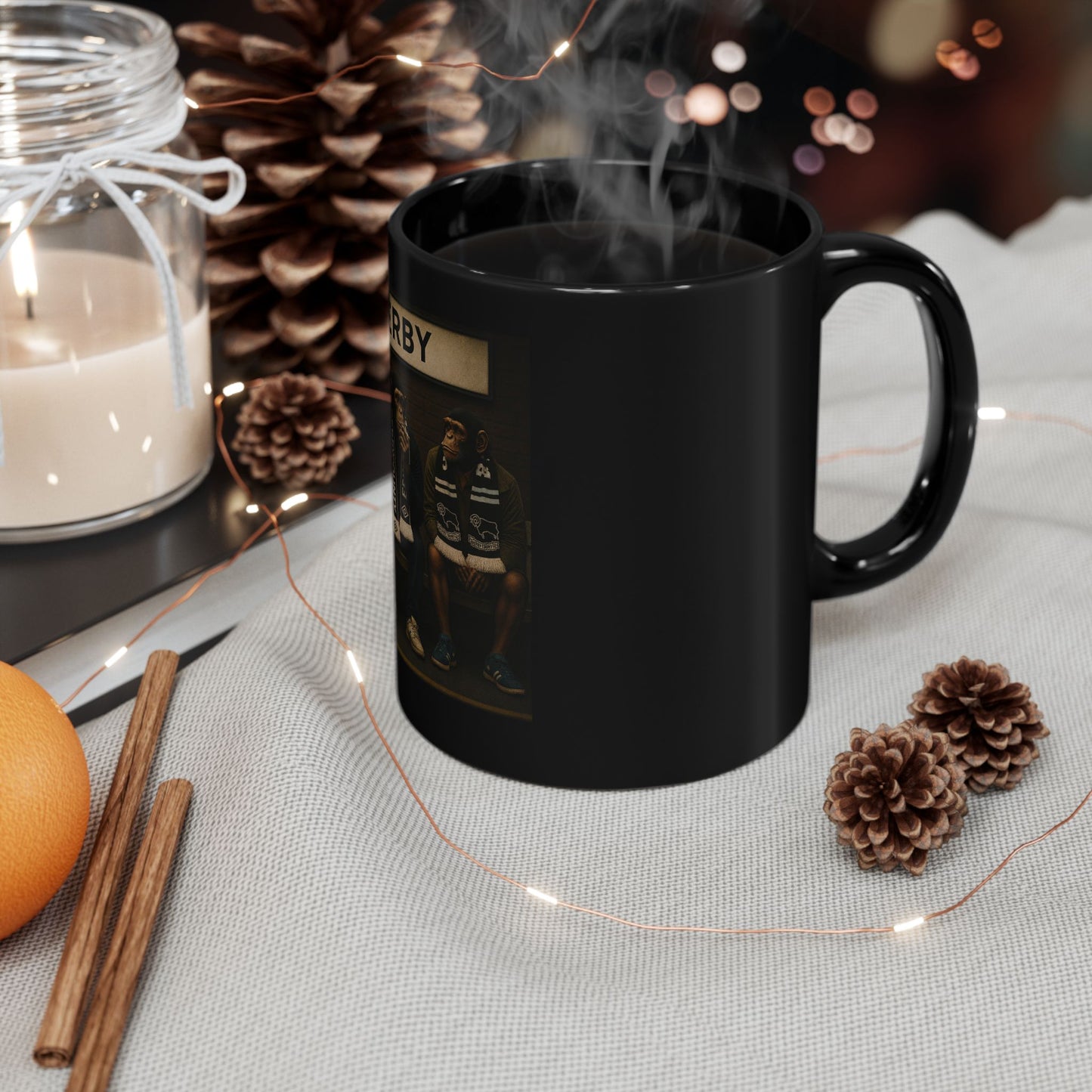 Black mug with text and graphics on a table with decorative items