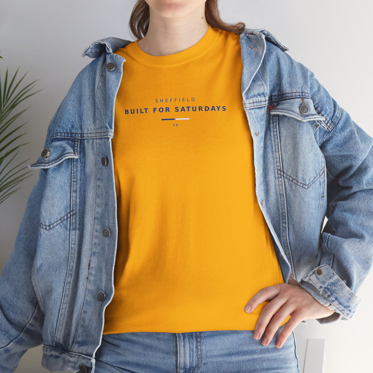 Woman in a denim jacket wearing the gold Sheffield Wednesday slogan tee