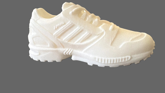 White Adidas ZX8000 sneaker on a textured surface