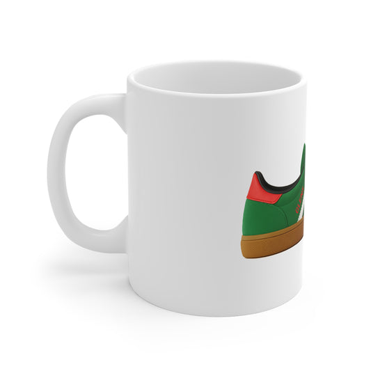 White ceramic mug featuring a green and red sneaker with gum sole design