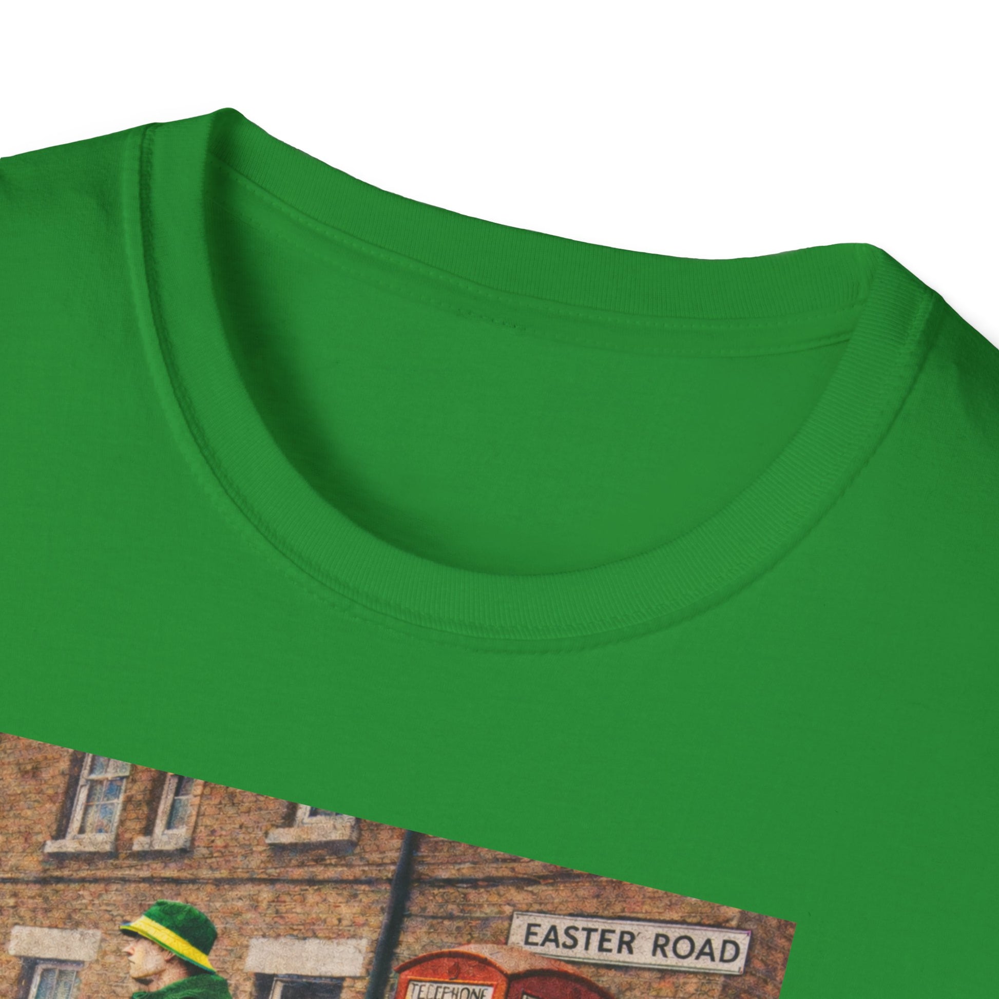 Close up Hibernian t-shirt featuring a casual man in green jacket, yellow hat, and sneakers standing by a red phone booth on Easter Road street
