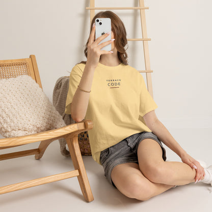 Woman sitting in a chair wearing the pale yellow Terrace Code T-shirt