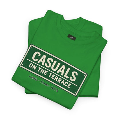 A folded a Hibernian green heavy cotton t-shirt flat lay featuring a central vintage green and white street sign graphic reading "CASUALS ON THE TERRACE" with "Leith • Since 1875" printed below, and an inner neck label for On The Terrace', displayed on a clean white background.