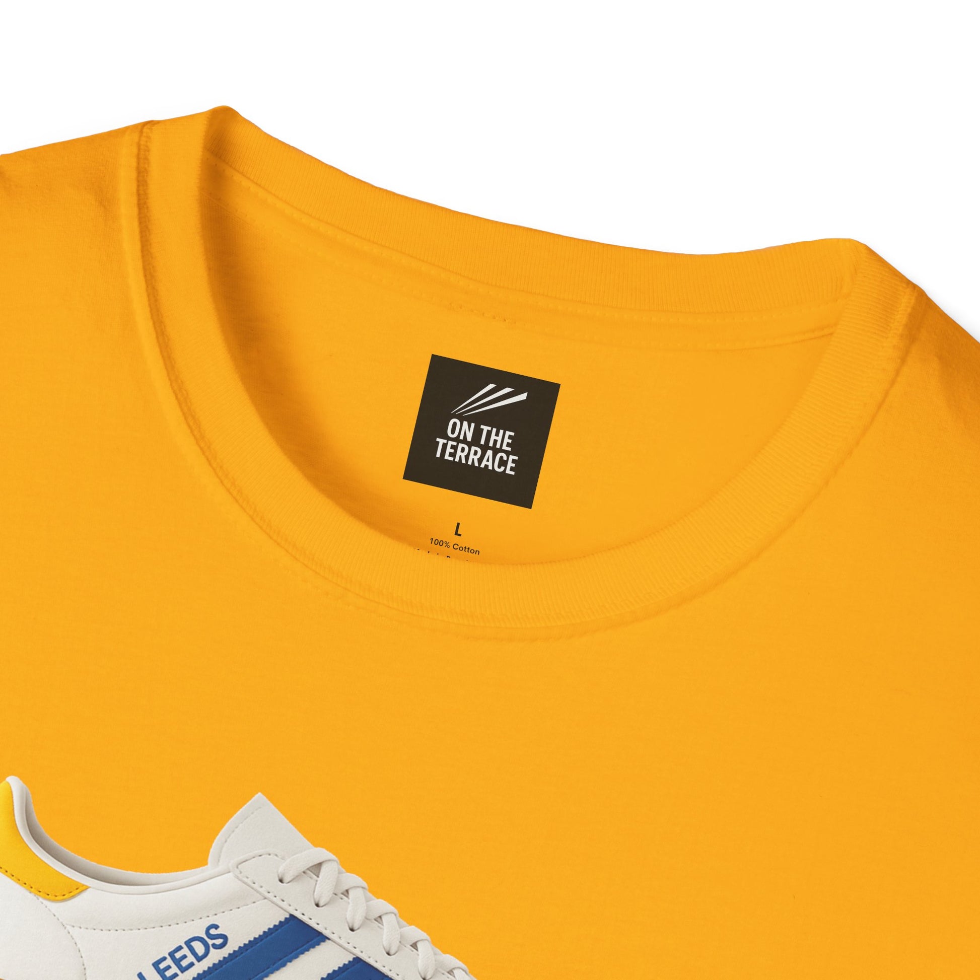 Yellow cotton t-shirt with On The Terrace label and partial view of white Leeds sneaker with blue stripe