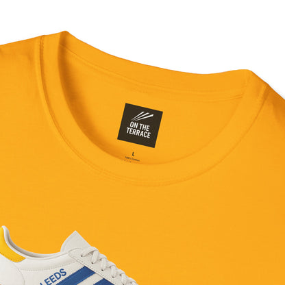 Leeds United  Yellow cotton t-shirt with On The Terrace label and partial view of white Leeds sneaker with blue stripe