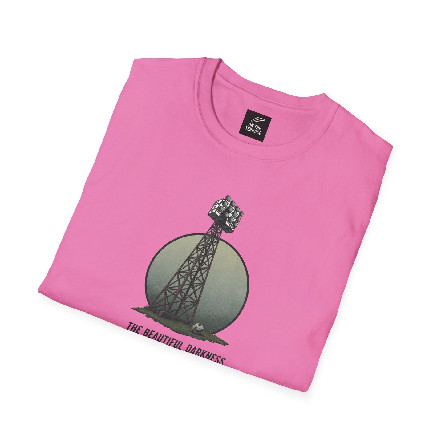 Pink folded t-shirt with football stadium floodlight tower, soccer ball, and text The Beautiful Darkness