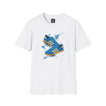 White t-shirt with a graphic print of a blue suede trainer with cream three stripes and gum sole, set against a blue and gold paint-splash background, On The Terrace neck label visible.