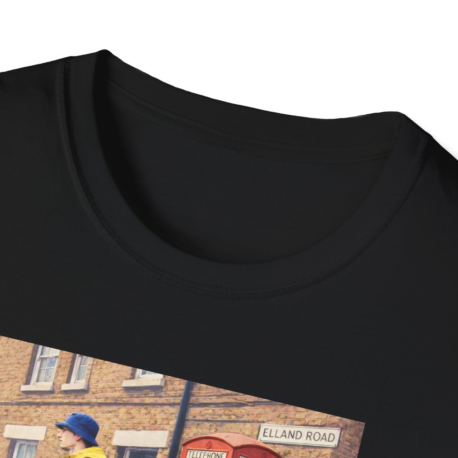 Close up of a Black Leeds t-shirt featuring a football casual print of a man in a yellow jacket and blue hat by a classic red British phone booth on Elland Road