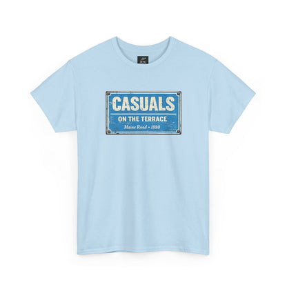 A sky blue MCFC t-shirt featuring a central vintage blue and white street sign graphic reading "CASUALS ON THE TERRACE" with "Maine Road • 1880" printed below, and an inner neck label for On The Terrace.
