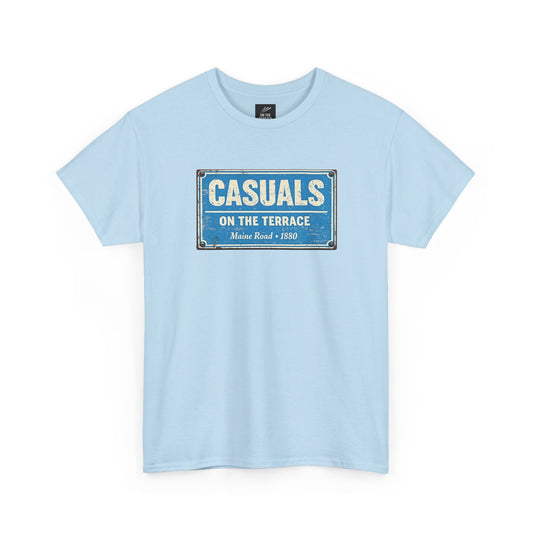 A sky blue MCFC t-shirt featuring a central vintage blue and white street sign graphic reading "CASUALS ON THE TERRACE" with "Maine Road • 1880" printed below, and an inner neck label for On The Terrace.