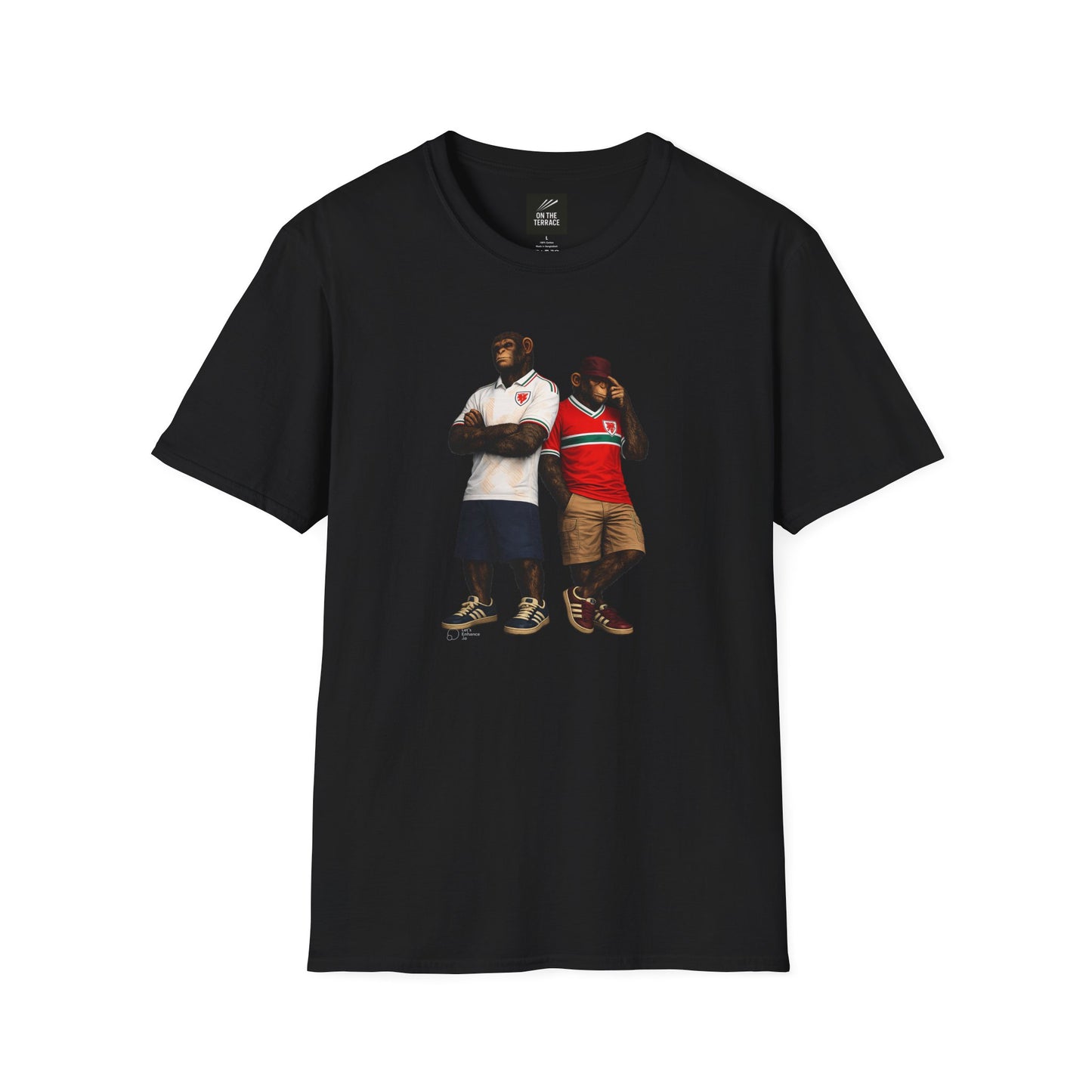 A black short-sleeved t-shirt featuring a central graphic of two chimpanzees styled as Wales national football team supporters. The chimpanzee on the left stands with arms crossed, wearing a white away jersey with green and red trim on the collar and a red dragon crest. The chimpanzee on the right wears the classic red Wales home jersey featuring a prominent green and white horizontal chest stripe, paired with khaki cargo shorts and a burgundy bucket hat