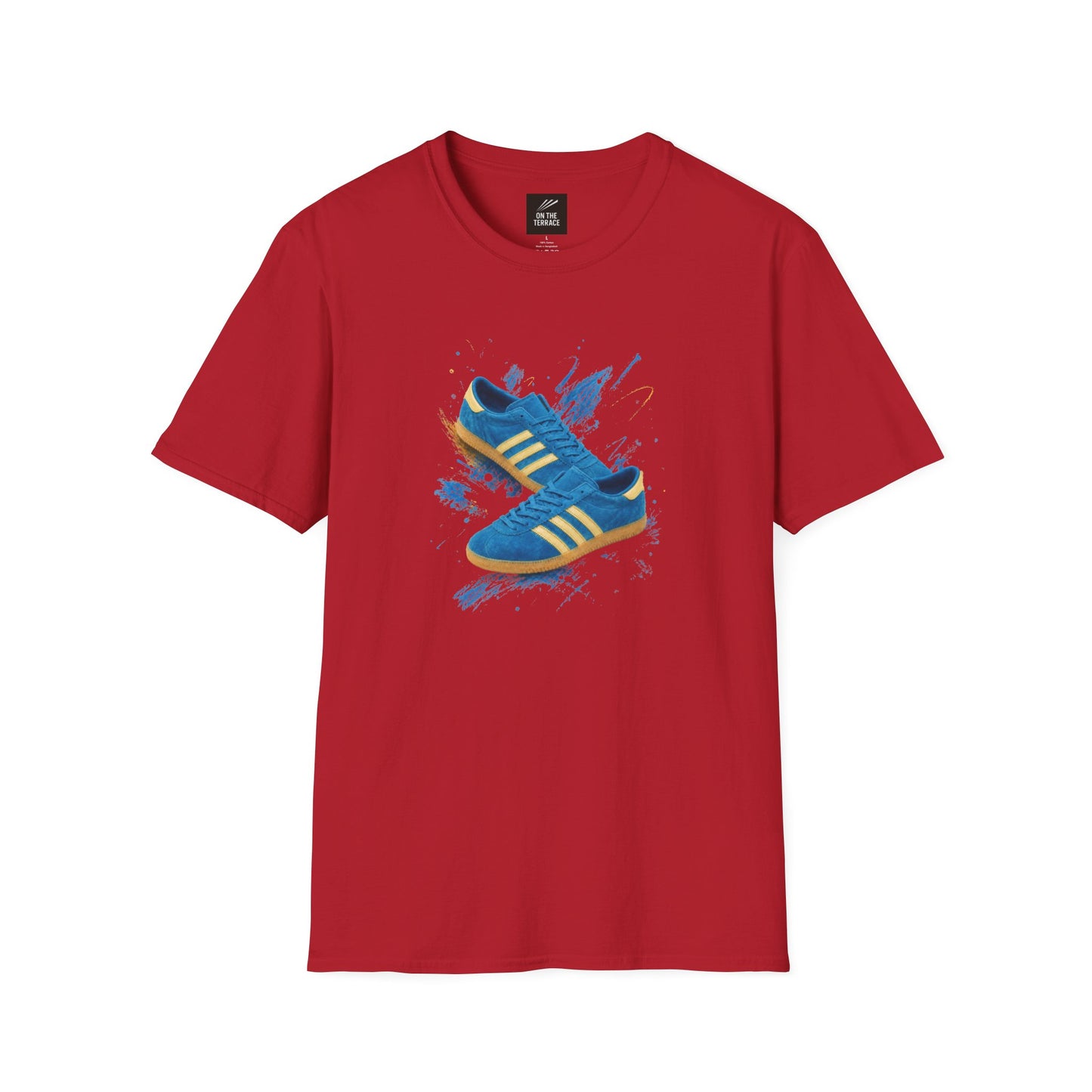 Red Gildan Softstyle t-shirt with a graphic print of a blue suede trainer with cream three stripes and gum sole, set against a blue and gold paint-splash background, On The Terrace neck label visible.