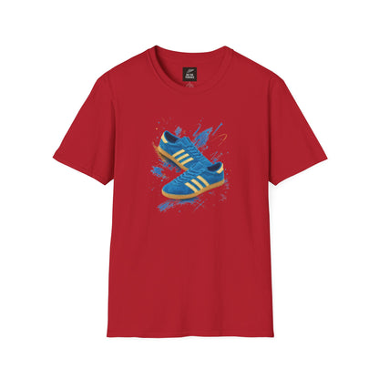 Red Gildan Softstyle t-shirt with a graphic print of a blue suede trainer with cream three stripes and gum sole, set against a blue and gold paint-splash background, On The Terrace neck label visible.