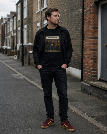 A man stands on a city street wearing a black zip-up jacket over a black graphic T-shirt with the word 'BRADFORD', paired with black jeans and burgundy sneakers with gold stripes.