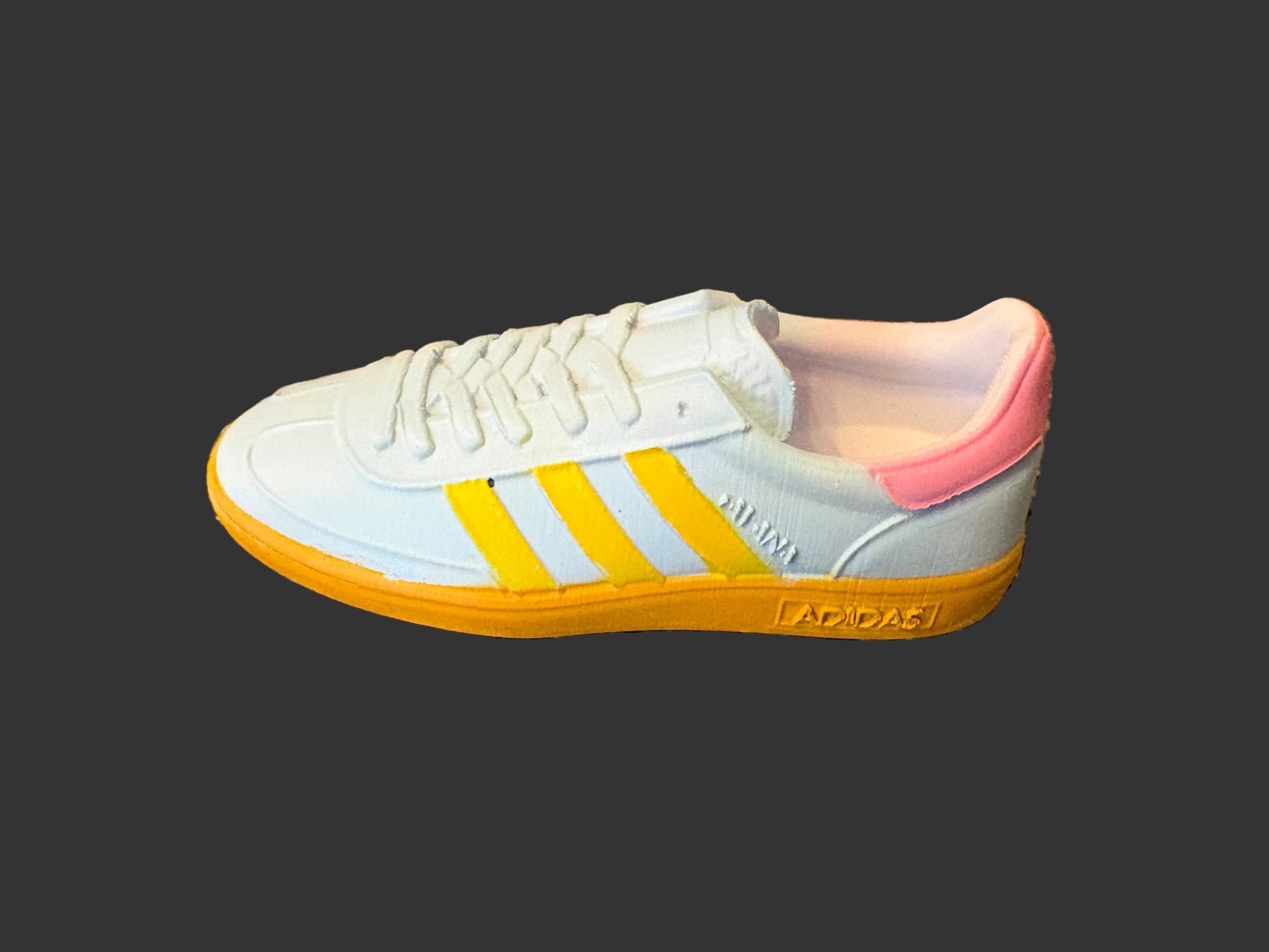 Adidas Havana 3d model with yellow stripes and pink heel on a textured surface