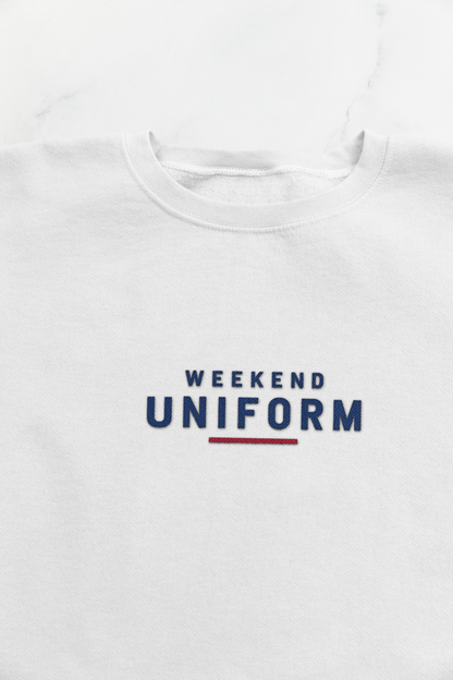 Close-up of the navy and red Weekend Uniform embroidery on the white sweatshirt