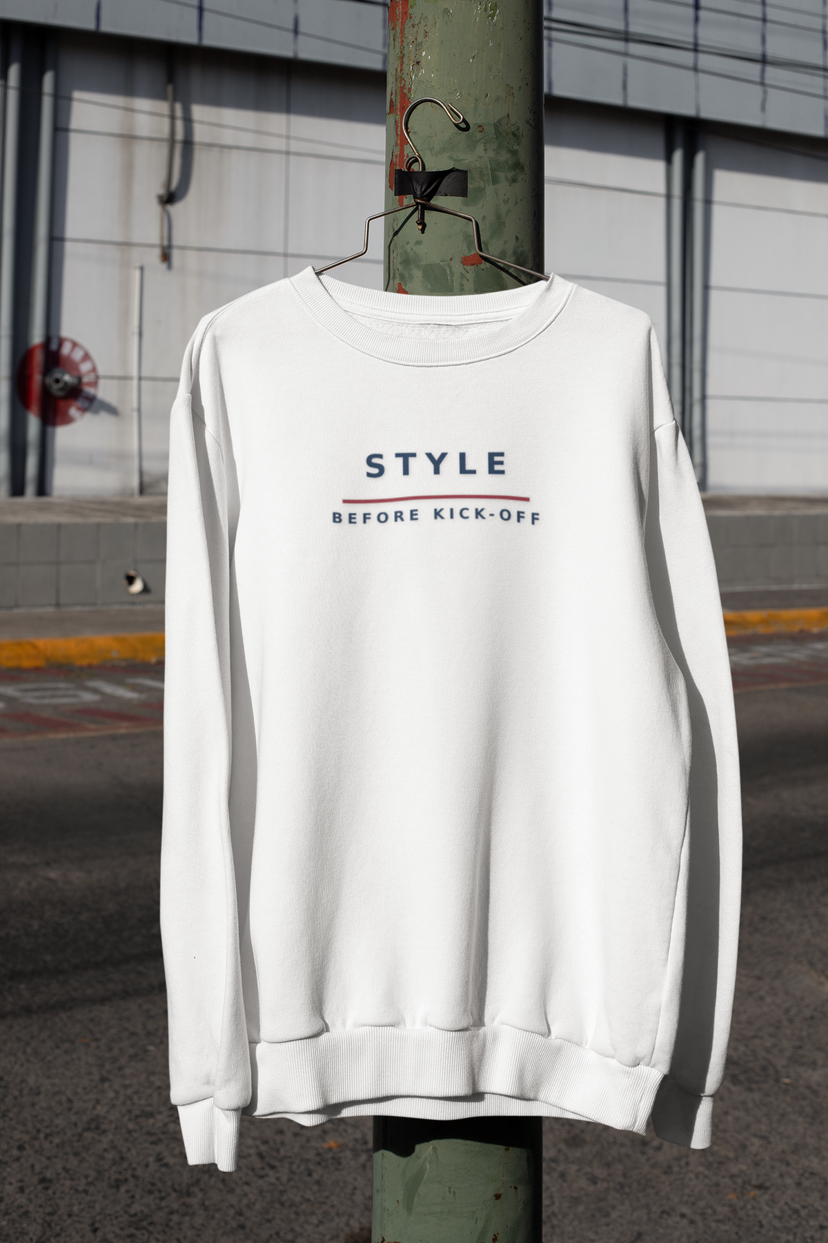White Style Before Kick-Off embroidered sweatshirt hanging from a lamppost on a city street