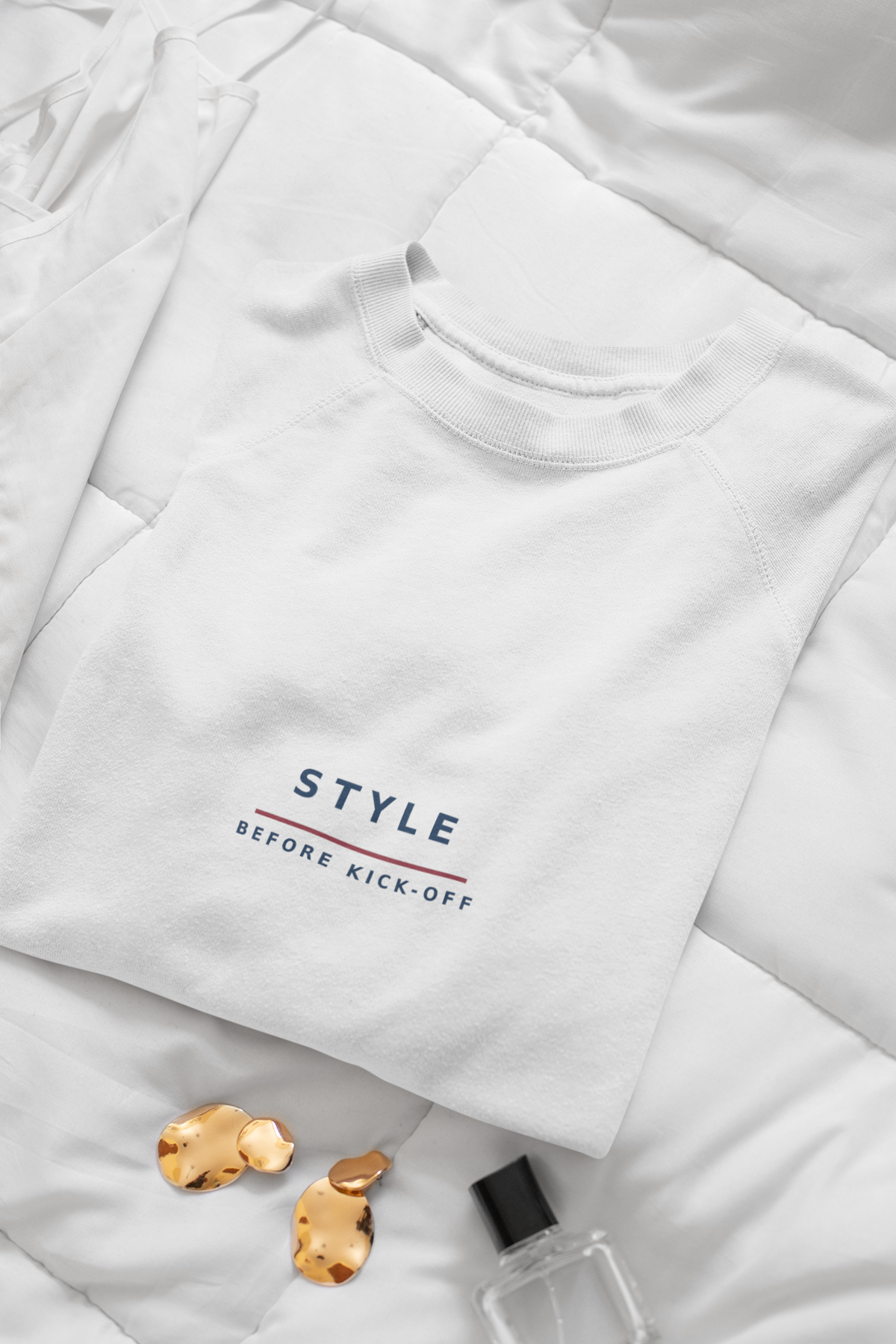 Folded white sweatshirt showing the STYLE BEFORE KICK-OFF embroidery close up