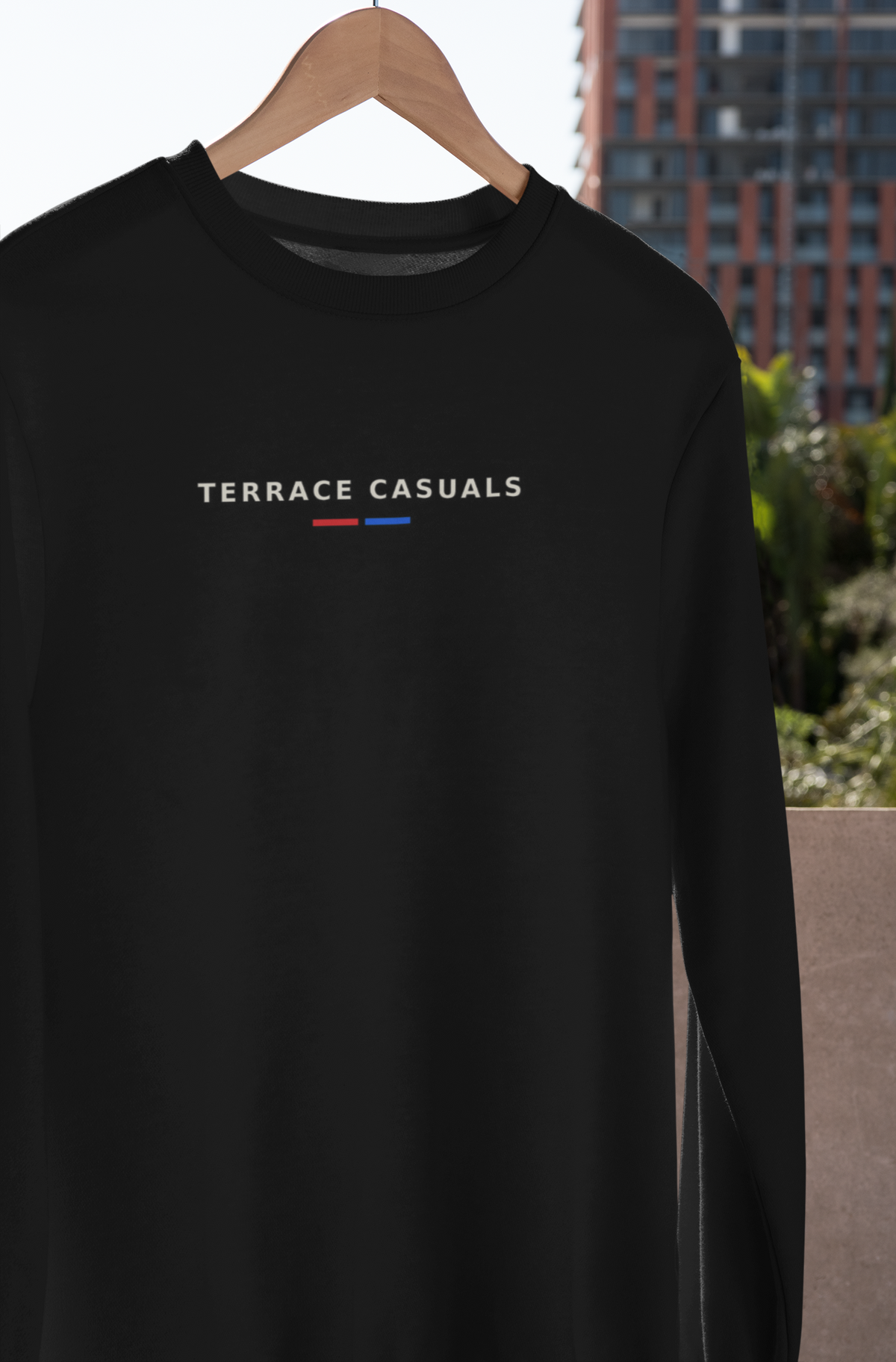 Black Terrace Casuals sweatshirt on a hanger outdoors, white lettering with red and blue bars