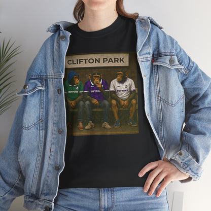 A person wearing a black graphic Reytons T-shirt with a 'Clifton Park' sports illustration, layered under an open light-wash denim jacket and paired with blue jeans.