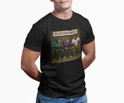 A man wearing a black graphic Reytons t-shirt with a 'Clifton Park' art print on the front, paired with blue jeans, against a plain white background.