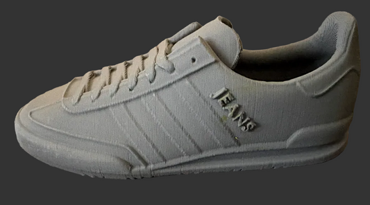 Gray adidas sneaker with 'JEANS' branding on a textured surface