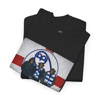 A folded black crewneck swfc tee featuring a graphic print of the Three Stooges wearing blue and white striped scarves, set against a red and white background with a blue circular logo.