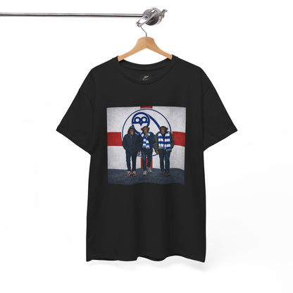 A black short-sleeve swfc t-shirt hanging on a wooden hanger from a metal rack, featuring a graphic print of the band Death Cab for Cutlass on a white, red, and blue background.