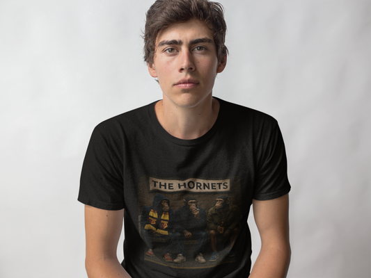 A young man wearing a black Watford t-shirt with a vintage-style graphic of hockey players and the text 'THE HORNETS' on the front, set against a plain light gray background.